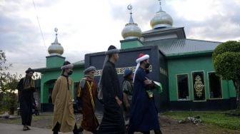 Jamaah An Nadzir berjalan untuk melaksanakan shalat Idul Fitri di Kampung Butta Ejayya, Kecamatan Bontomarannu, Kabupaten Gowa, Sulawesi Selatan, Rabu (12/5/2021). ANTARA FOTO/Abriawan Abhe

