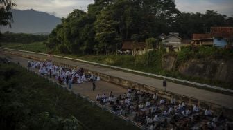 Warga menunggu pelaksanakan Shalat Idul Fitri di ruas Jalan Tol Cileunyi-Sumedang-Dawuan (Cisumdawu) di Pamulihan, Kabupaten Sumedang, Jawa Barat, Kamis (13/5/2021). [ANTARA FOTO/Raisan Al Farisi]