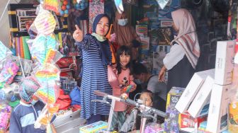 Warga membeli mainan di Pasar Gembrong, Jakarta Timur, Jumat (14/5/2021). [Suara.com/Alfian Winanto]