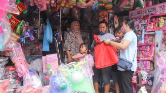 Warga membeli mainan di Pasar Gembrong, Jakarta Timur, Jumat (14/5/2021). [Suara.com/Alfian Winanto]