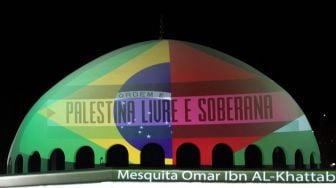 Bendera nasional Brasil dan Palestina terpantul dari proyektor di kubah masjid Omar Ibn Al-Khattab di Foz do lguacu, Brasil, Jumat (14/5/2021). CHRISTIAN RIZZI / AFP

