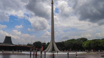 Warga berwisata di sekitar area tugu api Taman Mini Indonesia Indah, Jakarta Timur, Sabtu (15/5/2021). [Suara.com/Alfian Winanto]