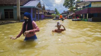 Sejumlah warga menerobos banjir yang merendam permukiman di Jalan Biduri, Kecamatan Satui, Kabupaten Tanah Bumbu , Kalimantan Selatan, Sabtu (15/5/2021). [ANTARA FOTO/Bayu Pratama S]