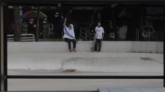 Dua anak bermain di Taman Puring, Kebayoran Baru, Jakarta, Minggu (16/5/2021). [Suara.com/Angga Budhiyanto]
