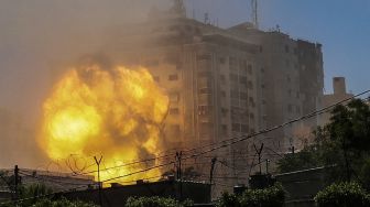 Bola api meletus dari Menara Jala dalam serangan udara Israel di Kota Gaza, Gaza, Palestina, pada (15/5/2021). [MOHAMMED ABED / AFP]