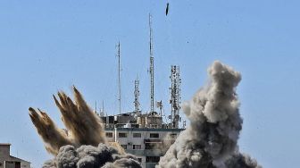 Asap mengepul saat bom udara dijatuhkan di Menara Jala selama serangan udara Israel di kota Gaza, Palestina, pada (15/5/2021). [Mahmud Hams / AFP]