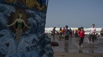 Wisatawan bermain air di Pantai Parangtritis, Bantul, DI Yogyakarta, Minggu (16/5/2021). [ANTARA FOTO/Hendra Nurdiyansyah]