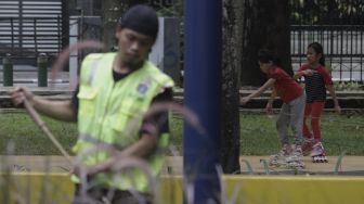 Dua anak bermain sepatu roda di Taman Puring, Kebayoran Baru, Jakarta, Minggu (16/5/2021). [Suara.com/Angga Budhiyanto]