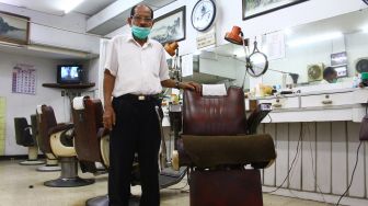 Pemangkas rambut Sukadi berpose di gerai pangkas rambut Sahabat di komplek pertokoan Kayutangan Heritage, Malang, Jawa Timur, Senin (17/5/2021). ANTARA FOTO/Ari Bowo Sucipto