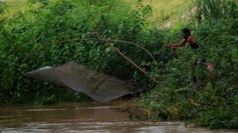 Warga menjaring ikan di Kali Serdang, Bekasi, Selasa (18/5/2021). [Suara.com/Dian Latifah]