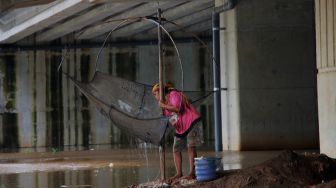 Warga menjaring ikan di Kali Serdang, Bekasi, Selasa (18/5/2021). [Suara.com/Dian Latifah]