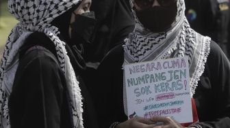 Massa aksi membawa poster saat mengikuti aksi solidaritas dukung Palestina terkait kekerasan yang terjadi beberapa waktu lalu oleh Israel di depan Kedubes AS, Jakarta, Selasa (18/5/2021). [Suara.com/Angga Budhiyanto]