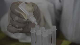 Tenaga Kesehatan melakukan uji sampel hasil swab test antigen milik warga yang telah balik dari mudik di GOR Kelurahan Kampung Makasar, Jakarta, Kamis (20/5/2021). [Suara.com/Angga Budhiyanto]