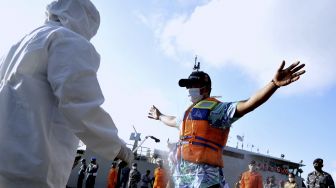 Petugas menyemprotkan cairan disinfektan kepada Anak Buah Kapal (ABK) KM Bandar Nelayan 188 yang tiba di Pelabuhan Benoa, Denpasar, Bali, Jumat (21/5/2021). [ANTARA FOTO/Fikri Yusuf]