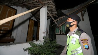 Personel kepolisian mengecek kondisi rumah warga yang rusak pascagempa di Desa Ploso Kecamatan Selopuro, Blitar, Jawa Timur, Jumat (21/5/2021). [ANTARA FOTO/Irfan Anshori]