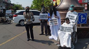 Personel Polres Madiun Kota menggelar sosialisasi imbauan penerapan protokol kesehatan (prokes) COVID-19 di Kota Madiun, Jawa Timur, Sabtu (22/5/2021).  ANTARA FOTO/Siswowidodo