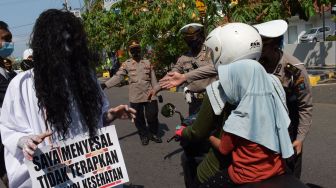 Personel Polres Madiun Kota menggelar sosialisasi imbauan penerapan protokol kesehatan (prokes) COVID-19 di Kota Madiun, Jawa Timur, Sabtu (22/5/2021).  ANTARA FOTO/Siswowidodo