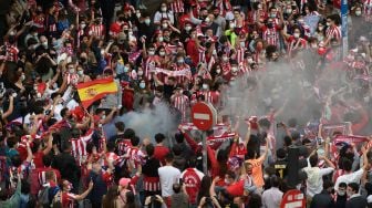 Fans Atletico Madrid turun ke jalan untuk merayakan kesuksesan tim kesayangannya meraih juara La Liga, Madrid, Spanyol, Sabtu (22/5). OSCAR DEL POZO / AFP