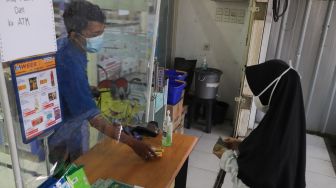 Pembeli berbelanja di minimarket dengan sistem Pesan Bayar Antar di Kawasan Cilangkap, Jakarta Timur, Minggu (23/5/2021). [Suara.com/Alfian Winanto]