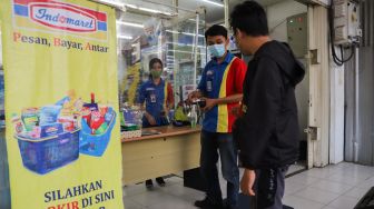 Pembeli berbelanja di minimarket dengan sistem Pesan Bayar Antar di Kawasan Cilangkap, Jakarta Timur, Minggu (23/5/2021). [Suara.com/Alfian Winanto]