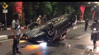 Mobil Mewah Porsche Hitam Terguling di Jalan Antasari