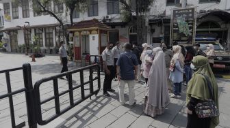 Sejumlah pengunjung mengantre untuk memasuki pelataran Museum Fatahillah di kawasan Wisata Kota Tua, Jakarta, Rabu (26/5/2021). [Suara.com/Angga Budhiyanto]