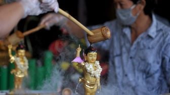 Umat Buddha menuangkan air bunga pada patung buddha rupang saat mengikuti kebaktian Hari Waisak di Vihara Buddha Dharma, Kuta, Badung, Bali, Rabu (26/5/2021). ANTARA FOTO