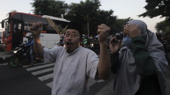 Massa pendukung Habib Rizieq Shihab berjalan saat dibubarkan oleh petugas kepolisian usai sidang putusan Habib Rizieq Shihab di depan Pengadilan Negeri Jakarta Timur, Kamis (27/5/2021). [Suara.com/Angga Budhiyanto]