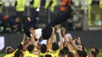Para pemain Villarreal melempar pelatih Villarreal Unai Emery ke udara saat mereka merayakan kemenangan pertandingan final Liga Eropa UEFA antara Villarreal CF melawan Manchester United di Stadion Gdansk, pada (26/5/2021). [MAJA HITIJ / POOL / AFP]