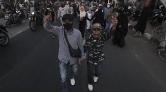 Massa pendukung Habib Rizieq Shihab berjalan saat dibubarkan oleh petugas kepolisian usai sidang putusan Habib Rizieq Shihab di depan Pengadilan Negeri Jakarta Timur, Kamis (27/5/2021). [Suara.com/Angga Budhiyanto]