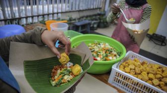 Pekerja memasak untuk kebutuhan gerakan nasi bungkus dua ribu di Jalan Natuna, Bandung, Jawa Barat, Kamis (27/5/2021). [ANTARA FOTO/Raisan Al Farisi]