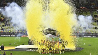 Para pemain Villarreal merayakan dengan trofi usai memenangkan pertandingan sepak bola final Liga Eropa UEFA antara Villarreal CF melawan Manchester United di Stadion Gdansk, pada (26/5/2021). [Adam Warzawa / AFP / POOL]