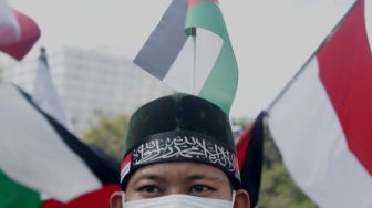 Massa mengikuti aksi solidaritas untuk Palestina di Jalan Medan Merdeka, Jakarta Pusat, Jumat (28/5/2021).  [Suara.com/Dian Latifah].