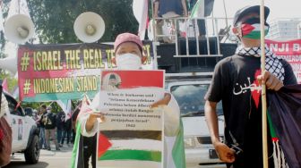 Massa mengikuti aksi solidaritas untuk Palestina di Jalan Medan Merdeka, Jakarta Pusat, Jumat (28/5/2021).  [Suara.com/Dian Latifah].