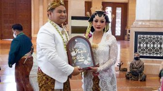 Pedangdut Nabila Gomes dan suaminya, Muhammad Reza usai melangsungkan akad nikah di Masjid Kubah Emas, Depok, Jawa Barat, Jumat (28/5/2021). [Suara.com/Alfian Winanto]