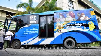 Sejumlah warga masuk ke bus Trans Metro Pekanbaru untuk vaksinasi COVID-19 di Kota Pekanbaru, Riau, Jumat (28/5/2021). ANTARA FOTO