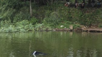 Sejumlah warga melihat pesawat latih yang jatuh di Setu Rawa Jemblung, Buperta, Depok, Jawa Barat, Jumat (28/5/2021). ANTARA FOTO/Asprilla Dwi Adha