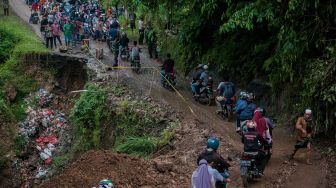 Sejumlah pengendara melintas di jalan yang longsor di Kecamatan Lebakgedong, Lebak, Banten, Minggu (30/5/2021). ANTARA FOTO/Muhammad Bagus Khoirunas
