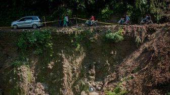 Sejumlah pengendara melintas di jalan yang longsor di Kecamatan Lebakgedong, Lebak, Banten, Minggu (30/5/2021). ANTARA FOTO/Muhammad Bagus Khoirunas
