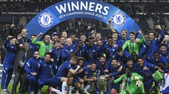 Bek Chelsea Cesar Azpilicueta (tengah) mengangkat trofi Liga Champions setelah memenangkan pertandingan final Liga Champions melawan Manchester City di Stadion Dragao, Porto, Portugal, Minggu (30/5/2021) dini hari WIB.  PIERRE-PHILIPPE MARCOU / POOL / AFP
