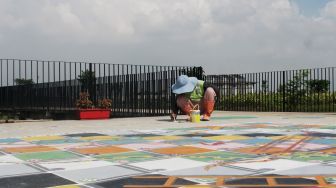 Petugas menyelesaikan pembuatan permainan tradisional di Taman Sungai Kendal, Cilincing, Jakarta Utara, Senin (31/5/2021). [Suara.com/Dian Latifah]