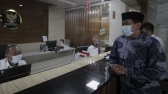 Koordinator Masyarakat Anti Korupsi Indonesia (MAKI) Boyamin Saiman (kedua kanan) berbincang dengan petugas usai memberikan berkas uji materi di Mahkamah Konstitusi, Jakarta, Senin (31/5/2021). [Suara.com/Angga Budhiyanto]