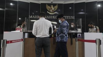 Koordinator Masyarakat Anti Korupsi Indonesia (MAKI) Boyamin Saiman (ketiga kanan) tiba untuk memberikan berkas uji materi di Mahkamah Konstitusi, Jakarta, Senin (31/5/2021). [Suara.com/Angga Budhiyanto]