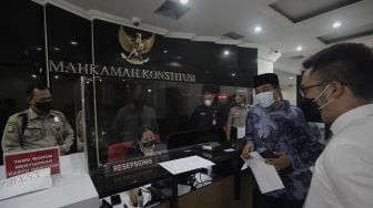 Koordinator Masyarakat Anti Korupsi Indonesia (MAKI) Boyamin Saiman (kedua kanan) tiba untuk memberikan berkas uji materi di Mahkamah Konstitusi, Jakarta, Senin (31/5/2021). [Suara.com/Angga Budhiyanto]