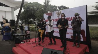 Pengamen jalanan bermain musik saat Peringatan Hari Lahir Pancasila di Kompleks Gelora Bung Karno, Jakarta, Selasa (1/6/2021). [Suara.com/Angga Budhiyanto]