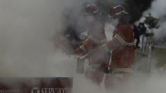 Petugas pemadam kebakaran melakukan simulasi penyelamatan saat kompetisi Fire Safety Challenge (FSC) antar Suku Dinas Pemadam Kebakaran di Kantor Dinas Penanggulangan Kebakaran dan Penyelamatan Pemprov DKI Jakarta, Gambir, Jakarta, Rabu (2/6/2021). [Suara.com/Angga Budhiyanto]