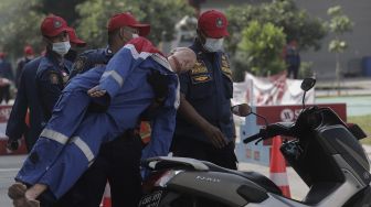 Petugas pemadam kebakaran membawa boneka manekin rescue usai melakukan simulasi penyelamatan dalam kompetisi Fire Safety Challenge (FSC) antar Suku Dinas Pemadam Kebakaran di Kantor Dinas Penanggulangan Kebakaran dan Penyelamatan Pemprov DKI Jakarta, Gambir, Jakarta, Rabu (2/6/2021). [Suara.com/Angga Budhiyanto]