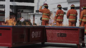 Petugas pemadam kebakaran melakukan simulasi penyelamatan saat kompetisi Fire Safety Challenge (FSC) antar Suku Dinas Pemadam Kebakaran di Kantor Dinas Penanggulangan Kebakaran dan Penyelamatan Pemprov DKI Jakarta, Gambir, Jakarta, Rabu (2/6/2021). [Suara.com/Angga Budhiyanto]