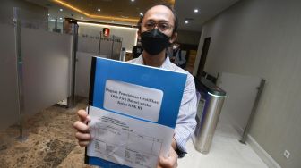 Peneliti Indonesia Corruption Watch (ICW) Wana Alamsyah menunjukan dokumen laporan saat tiba di Bareskrim Polri, Jakarta, Kamis (3/6/2021). ANTARA FOTO/Rivan Awal Lingga