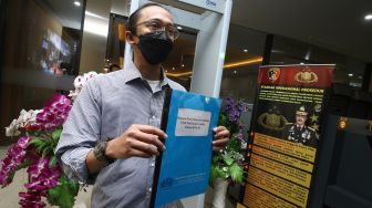 Peneliti Indonesia Corruption Watch (ICW) Wana Alamsyah menunjukan dokumen laporan saat tiba di Bareskrim Polri, Jakarta, Kamis (3/6/2021). ANTARA FOTO/Rivan Awal Lingga